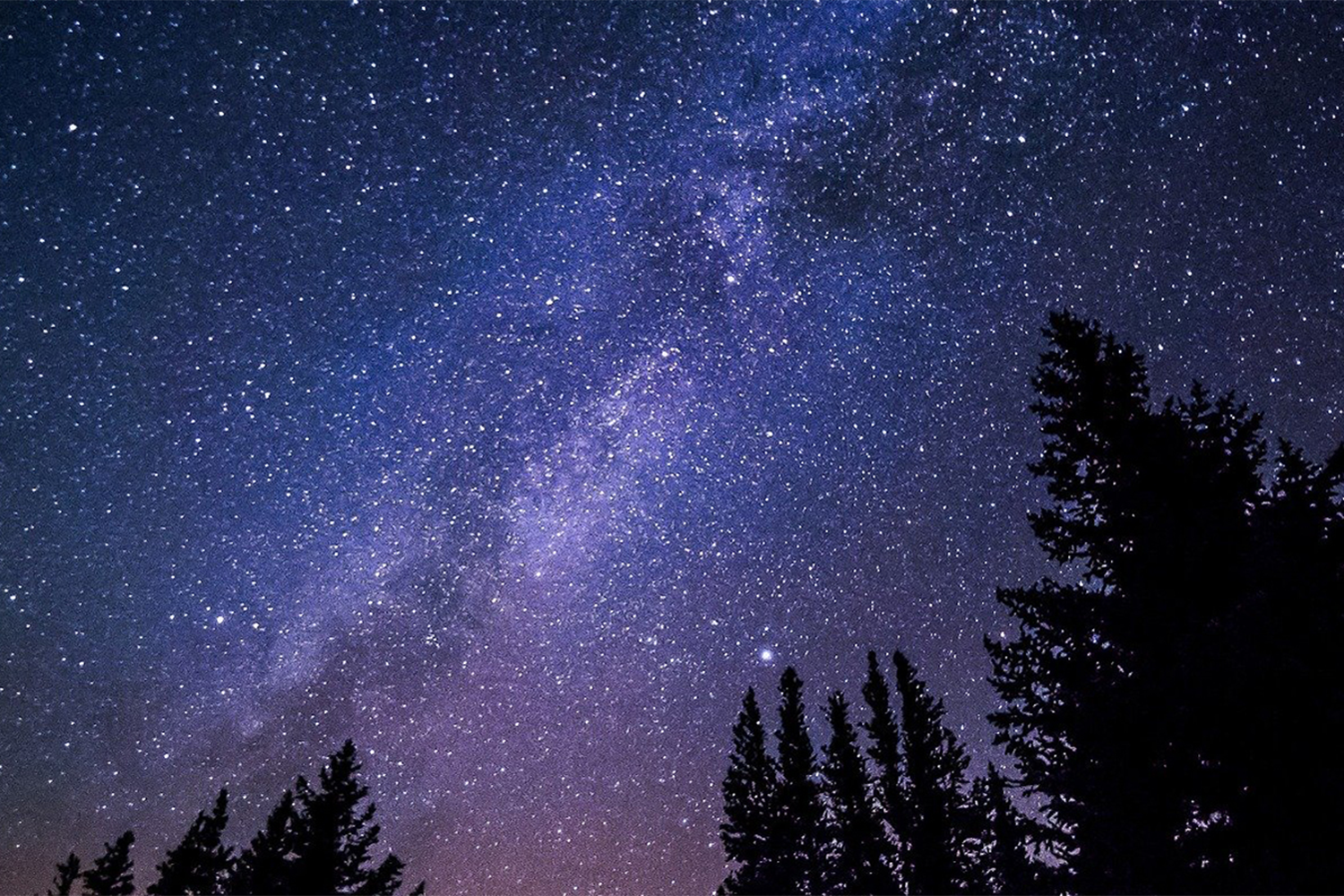 Image of the night sky in purple hues with many stars