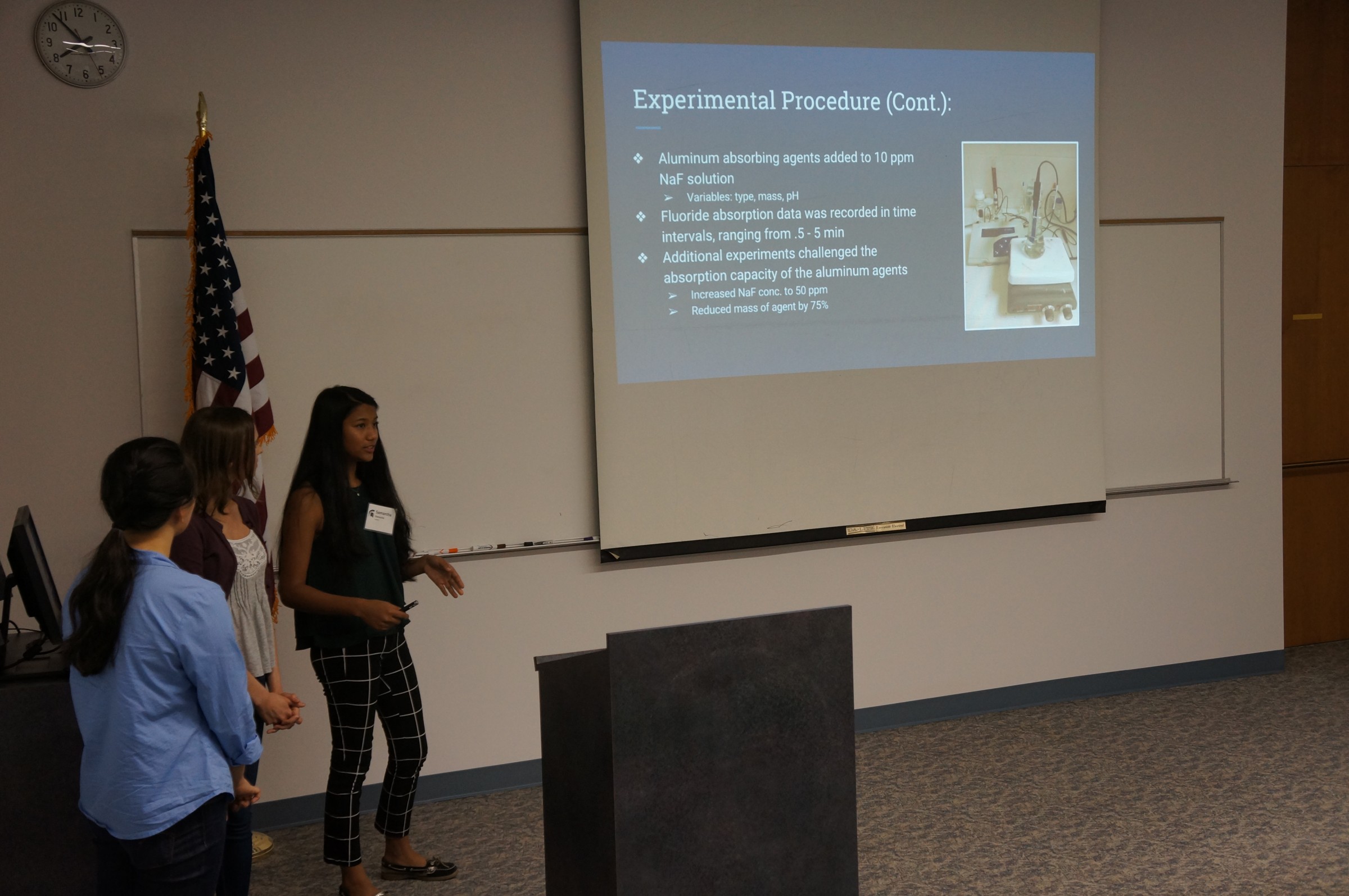 Three students presenting in front of a group