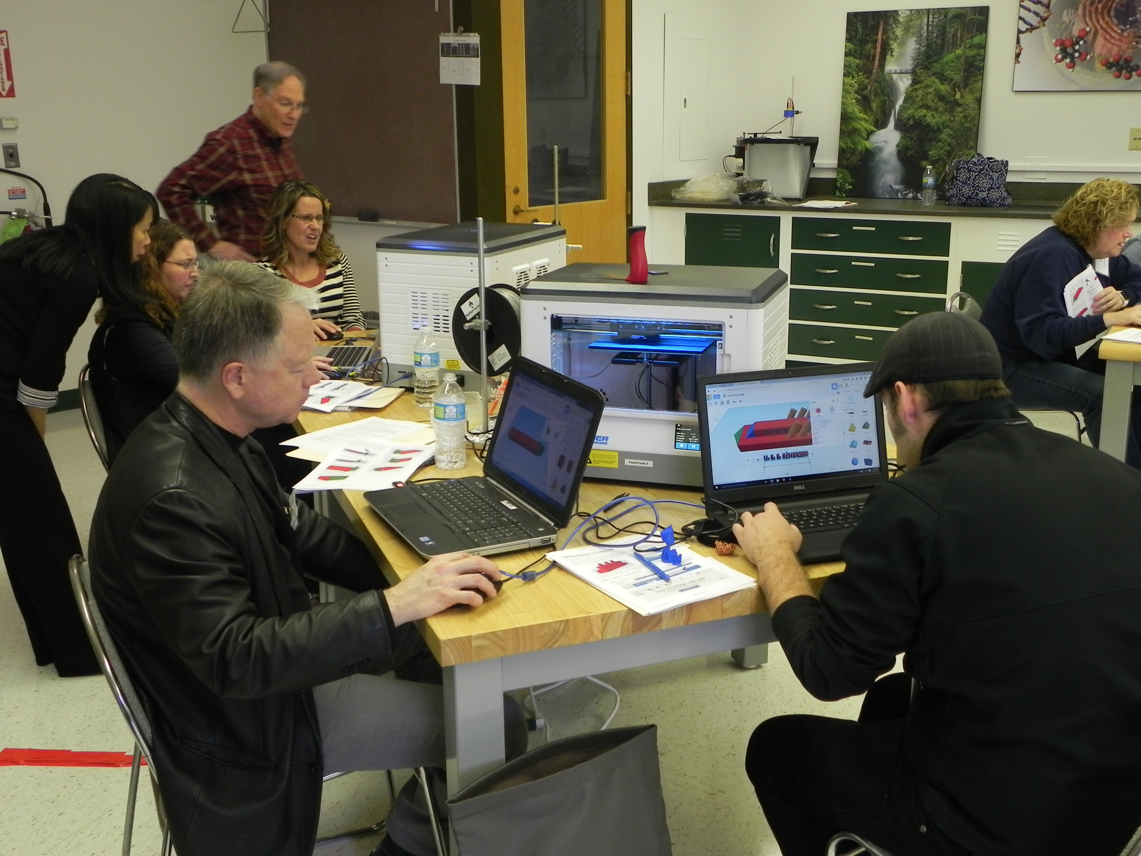 Teachers using 3D printers in a workshop setting