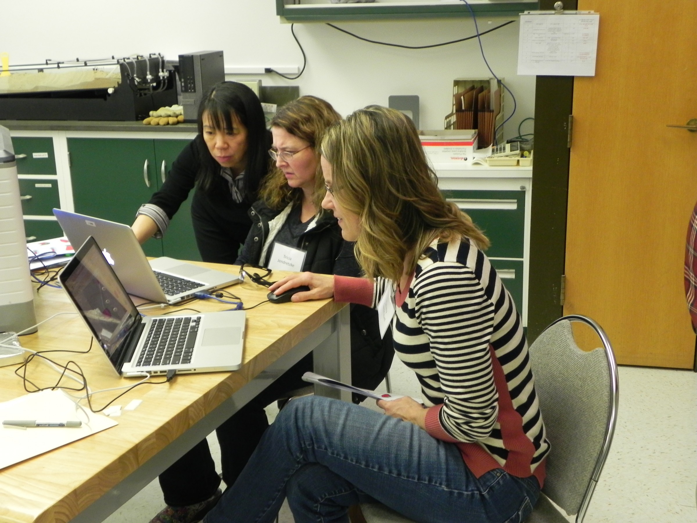 Three women working on project on laptop