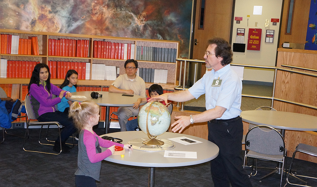 Professor Edmund Stark providing an astronomy lesson to a family